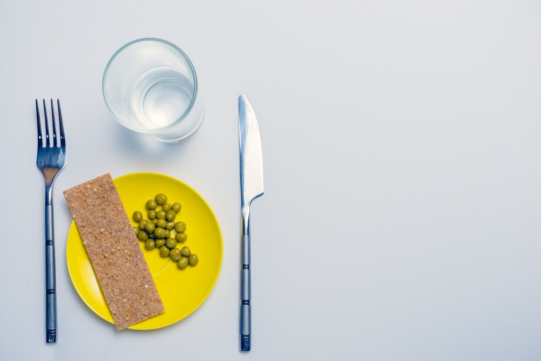 concept of dietary restrictions, healthy lifestyle, diet, weight loss, fight obesity, healthy eating. peas and bread on a plate, knife, fork